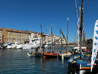Sète canal during the maritime festival: colourful traditional boats and tall ships, crowds along the bank