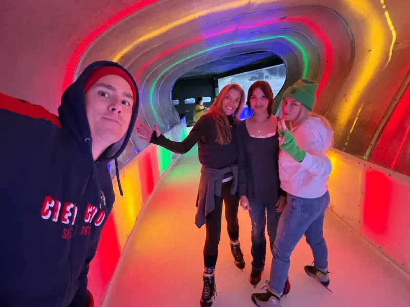 Four skaters in the colourfully lit tunnel of the Végapolis rink