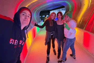 Four skaters in the colourfully lit tunnel of the Végapolis rink