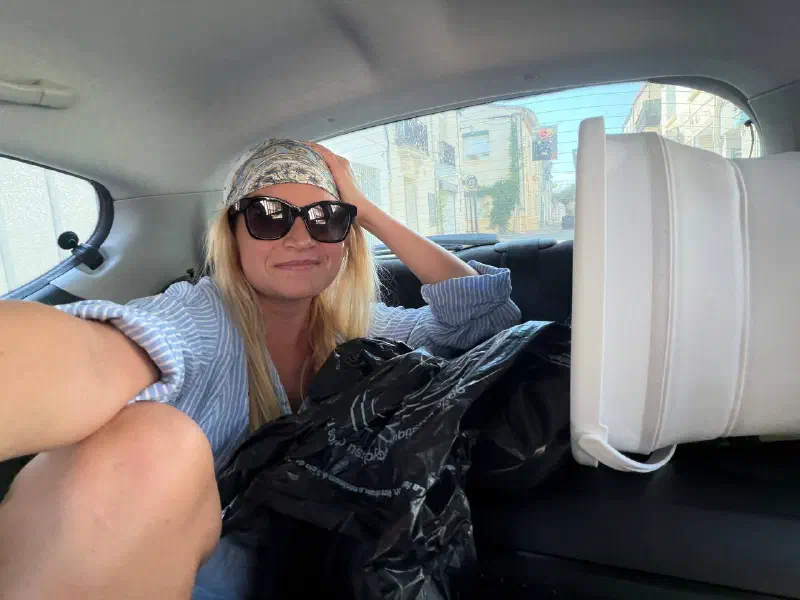 On the way to the beach: a participant in the back seat with a folding table and bags for the shared dinner