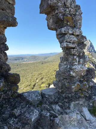 Gap in the ruined castle wall framing the valley and the rocky peak of Pic Saint-Loup