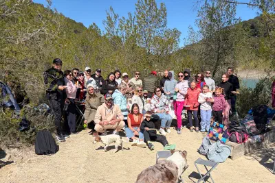 Group photo of the hike: about forty people with kids and dogs in a clearing by Lac de Cécélès