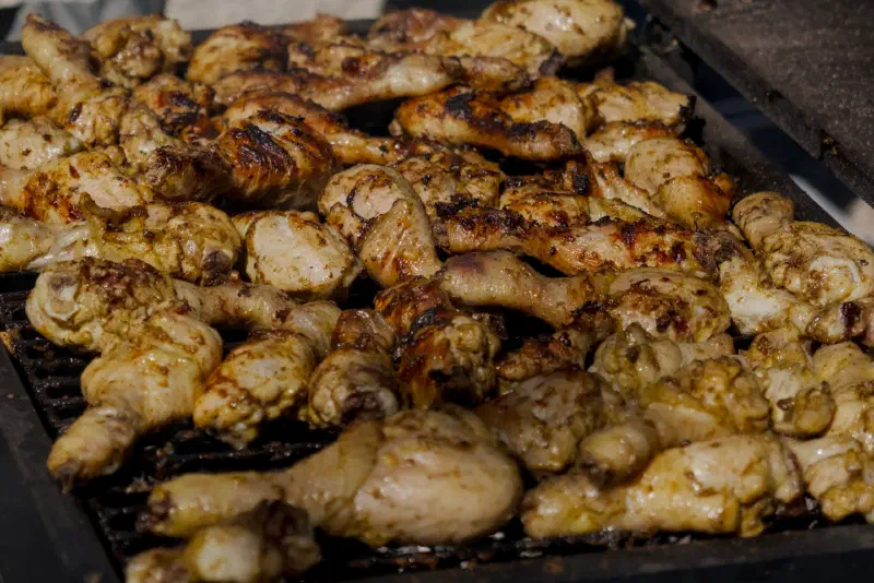 Chicken drumsticks with a golden crust on the barbecue grate