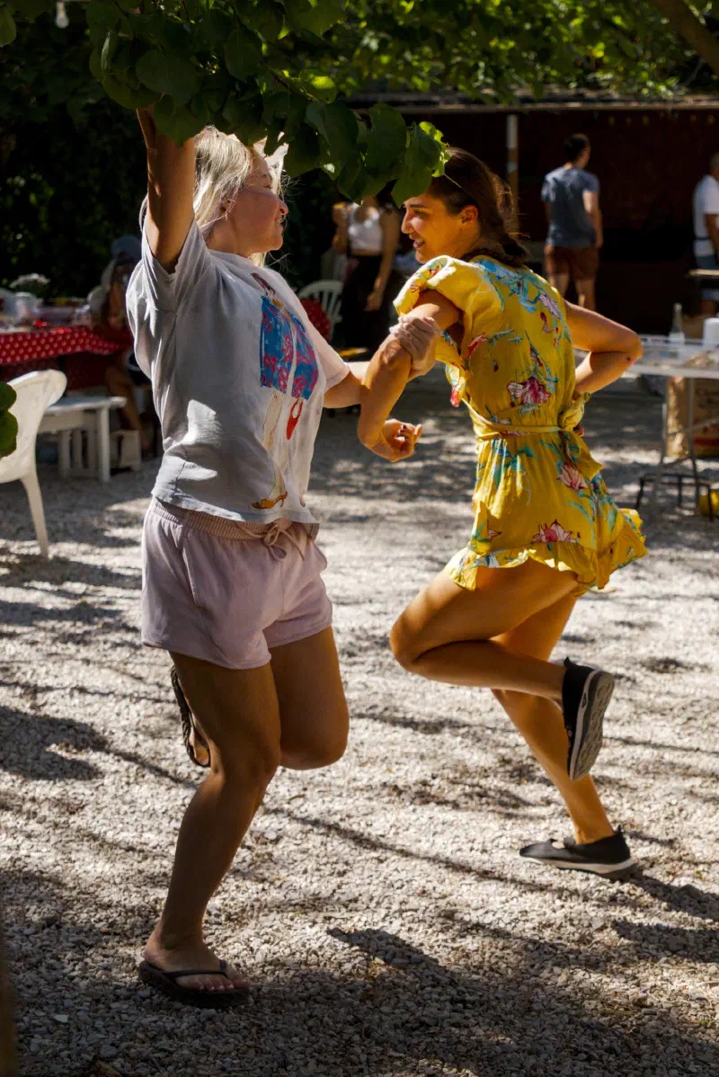 Two guests dancing on the gravel under a tree