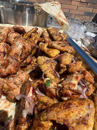 Tray of grilled chicken with red onion on lavash flatbread by the mangal