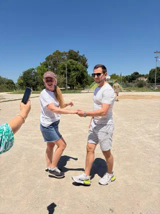 A couple practising salsa steps on the sunlit grounds