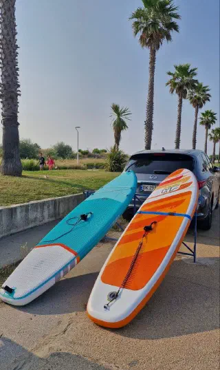 Two paddleboards by a car, ready for a summer trip to the sea
