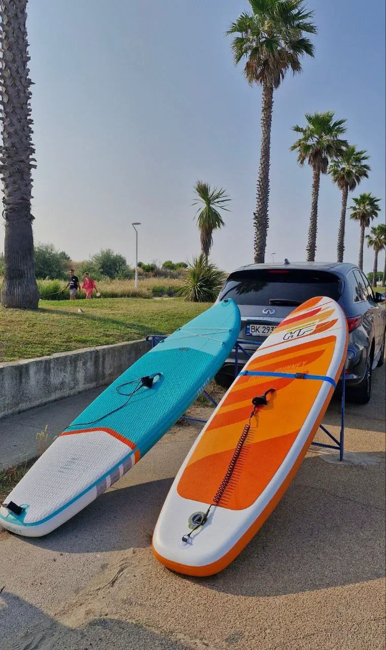 Two paddleboards by a car, ready for a summer trip to the sea