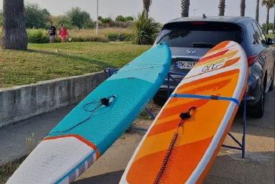 Two paddleboards by a car, ready for a summer trip to the sea